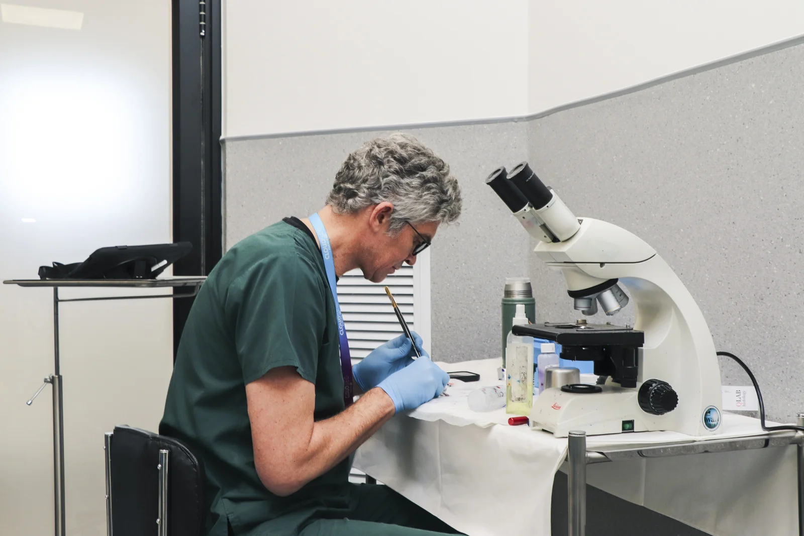 Pathologist examining slides at a microscope in the Epione diagnostics lab